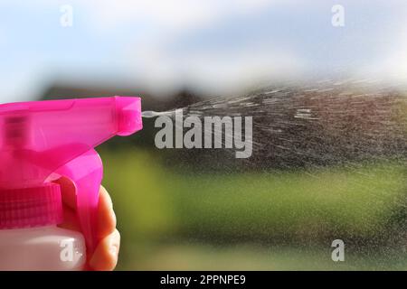 Pink Spray Bottle Action Shot, taken around noon outside. Perfect for anything garden or summer related :) Stock Photo