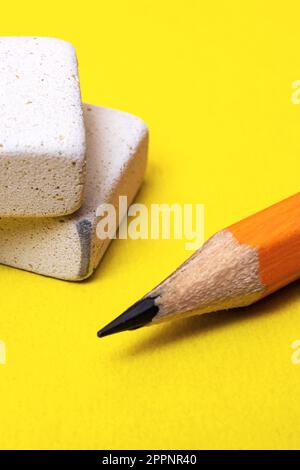 Two erasers and pencil on a yellow background Stock Photo