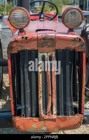 Front end view of an old red 1960s International B-414 tractor, with top mounted headlamps Stock Photo