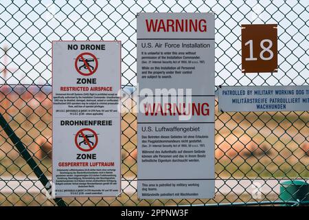 Bilingual 'no drone zone' restricted airspace warning signs on the fence of the U.S. military Air Base in Ramstein, Germany Stock Photo