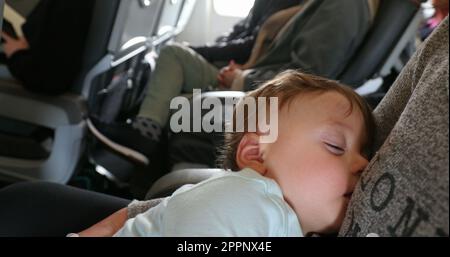 Baby asleep while traveling by plane. Infant sleeping during commercial flight Stock Photo