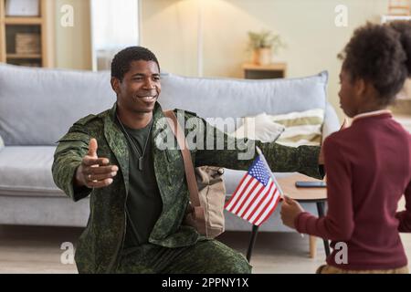 African American military dad coming back home, he embracing his little daughter Stock Photo