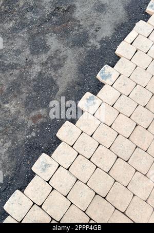 Laying yellow concrete paving slabs. Sidewalk or patio tile or slabs on a leveled sand base. Laying paving slabs in the pedestrian zone Stock Photo
