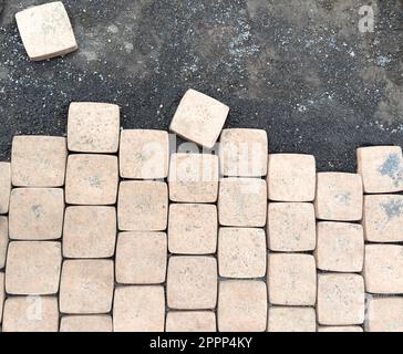 Laying yellow concrete paving slabs. Sidewalk or patio tile or slabs on a leveled sand base. Laying paving slabs in the pedestrian zone Stock Photo
