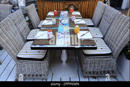 Wicker chairs and table in a street cafe Stock Photo