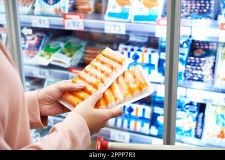 Crab sticks in the hands of the buyer in the store Stock Photo