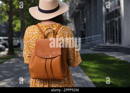 Young woman with stylish backpack on city street, back view Stock Photo