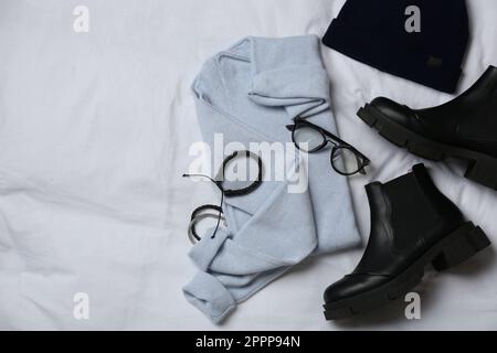 Stylish look with cashmere sweater, flat lay. Women's clothes and accessories on fabric Stock Photo