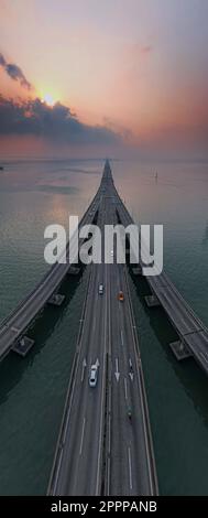 A vertical shot of a highway with multiple cars driving along the ...