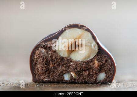 Half chocolate truffle centre topped with a whole hazelnut, close up. Delicious chocolate candy Stock Photo