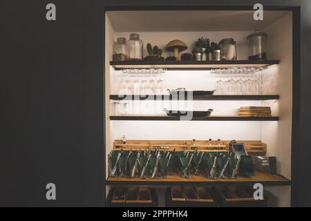 Set of utensils, glass wines and containers arranged on a wall wooden shelves in cafe or restaurant Stock Photo