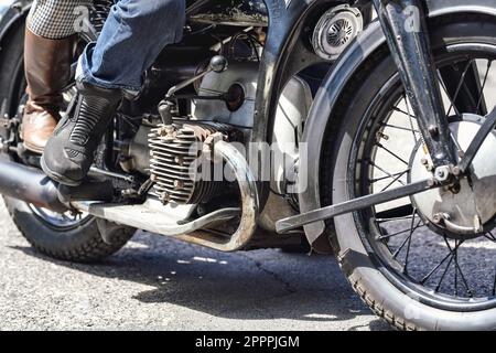 Man and woman leather boots on the vintage motorcycle, closeup detail Stock Photo
