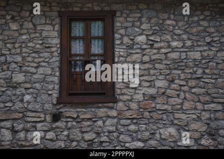 Natural stone facade with wooden window detail. Rural house in the Pyrenees. Copy space on the right side Stock Photo