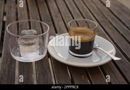 Espresso coffee with ice on a wooden table. Copy space Stock Photo