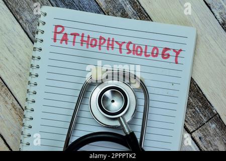 Concept of Pathophysiology write on book with stethoscope isolated on Wooden Table. Stock Photo