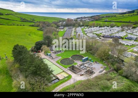 Seatown, Dorset, UK.  24th April 2023.  View from the air of the Mill Lane, Chideock sewage treatment works at Seatown in Dorset owned by Wessex Water.   In 2022, the sewer storm overflow, (Permit number: 401068) spilled 35 times for a total of 363.50 hours, discharging into the River Winniford, which is next to the sewage works.  Golden Cap Holiday Park is on the opposite bank of the river. (Source: https://theriverstrust.org/key-issues/sewage-in-rivers) Picture Credit: Graham Hunt/Alamy Live News Stock Photo