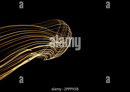 Abstract lights of golden colors forming patterns of curved lines. Festive decoration. Resource for designers. Stock Photo
