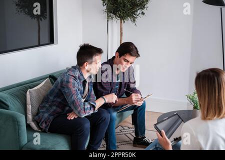 Young Lgtbi couple signing a contract to buy their house to live together and start a new life Stock Photo