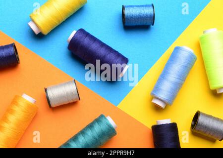 Composition with different sewing spools on color background Stock Photo