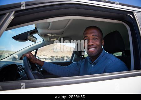 A smiling African businessman sitting in his car as he is about to leave Stock Photo