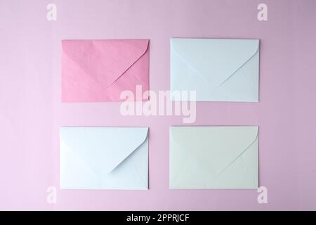 Colorful paper envelopes on pink background, flat lay Stock Photo