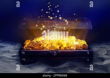 Open treasure chest with gold coins on sand seabed Stock Photo