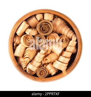 Spiral shaped wood shavings of Swiss pine, in wooden bowl. Pinus cembra, European white pine, with distinctive smell from essential oil pinosylvin. Stock Photo