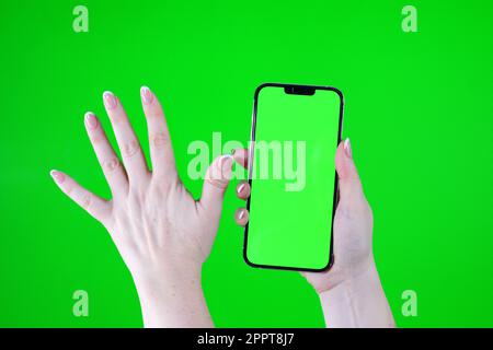 Stop concept with hand up. green screen chromakey female hand holding five fingers phone High quality photo Stock Photo