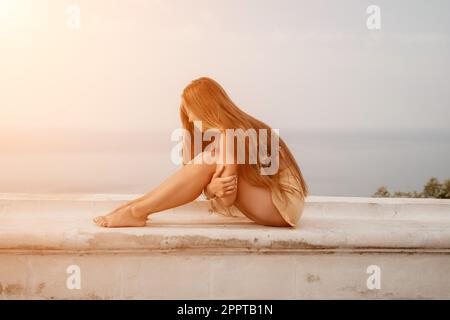 Woman park yoga. Side view of free calm bliss satisfied woman with long hair standing in morning park with yoga position against of sky by the sea. He Stock Photo