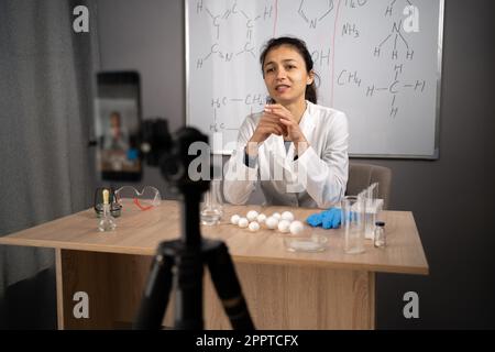 Chemistry teacher explaining formulas on whiteboard when hosting online class for school students Stock Photo