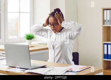 Stressed young woman clutching her head in panic Stock Photo