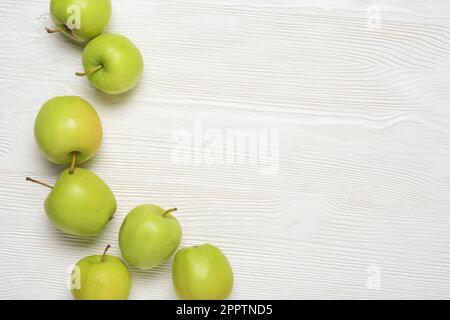 Green apples on the white wooden table. Top view with copy space, Stock Photo