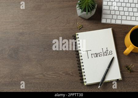 Word Translate written in notebook on wooden table, flat lay. Space for text Stock Photo