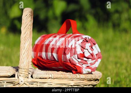 Checkered tablecloth on picnic basket outdoors, closeup Stock Photo