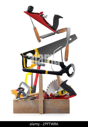 Different carpenter's tools falling into wooden box on white background Stock Photo