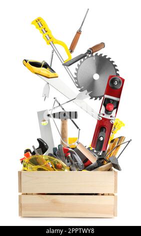 Different carpenter's tools falling into wooden box on white background Stock Photo