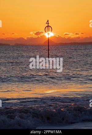 Portobello, Edinburgh, Scotland, UK. 25th April 2023. A nippy sunrise 2 degrees at dawn by the Firth of Forth with the sun slowly rising over the dark clouds on the horizon. Pictured: Berwick Law in the distance. Credit: Arch White/alamy live news. Stock Photo