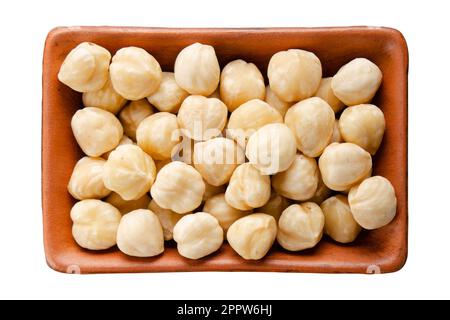 Hazelnuts in clay bowl isolated on white flat lay view Stock Photo