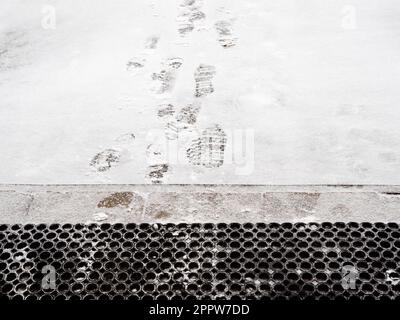 rubber, door mat and footprints on freshly fallen snow in front of porch of residential building Stock Photo