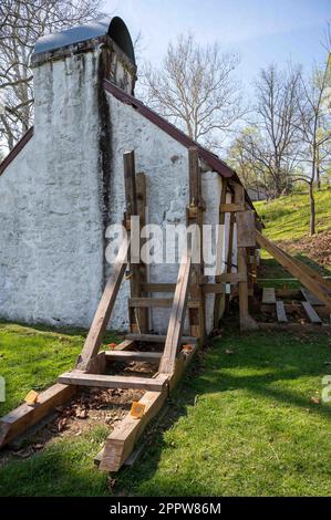 Wooden support scaffolding braces cracked wall of colonial cottage Stock Photo