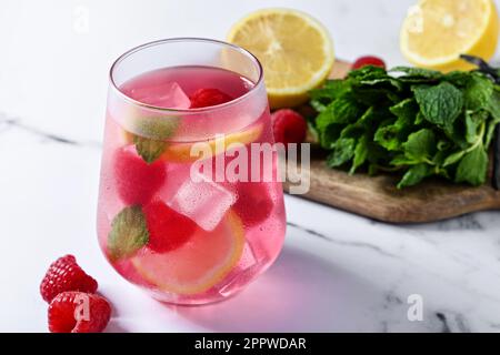 Raspberry lemonade drink in glass on white marble Stock Photo