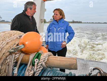 25 April 2023, Brandenburg, Küstrin-Kietz: Steffi Lemke (r, Bündnis 90/Die Grünen), Federal Minister for the Environment, is on board a research vessel on the German-Polish border river Oder talking to Christian Wolter from the Leibniz Institute of Freshwater Ecology and Inland Fisheries (IGB). During a scientific trawl survey, the Federal Environment Minister learned about the current situation following the environmental disaster in 2022. The massive fish kill in the Oder River in the summer of 2022 continues to be the subject of current research. The Leibniz Institute of Freshwater Ecology Stock Photo