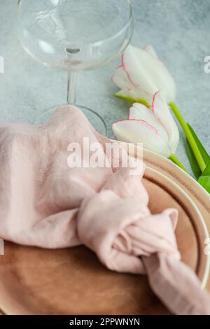 Close-up of a pink place setting with fresh tulips Stock Photo