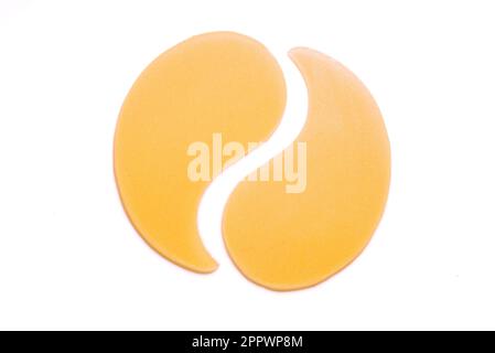 Hydrogel golden yellow eye patches isolated on white background. Cosmetic moisturizing under eye patches or pads with gold and collagen. Stock Photo