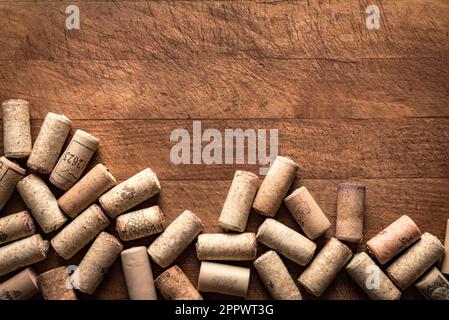 Bunch of wine corks on wooden table, top view, copy space. Wine cork stoppers close up. Stock Photo