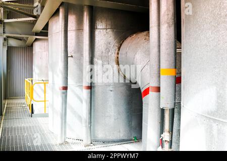 Large iron heat exchanger, tank, reactor, distillation column in thermal insulation of fiberglass and mineral wool of galvanized steel in the industri Stock Photo