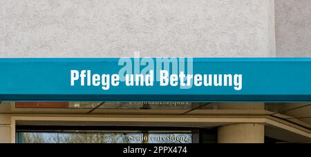 Sign on the wall of a nursing and retirement home. The text Pflege und Betreuung is German for nursing and care, Seniorenresidenz is German for senior Stock Photo