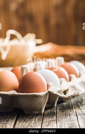 Whole chicken eggs in eggbox on the wooden table. Stock Photo