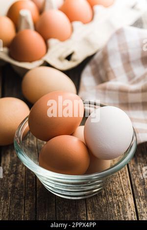 Whole chicken eggs in bowl on the wooden table. Stock Photo