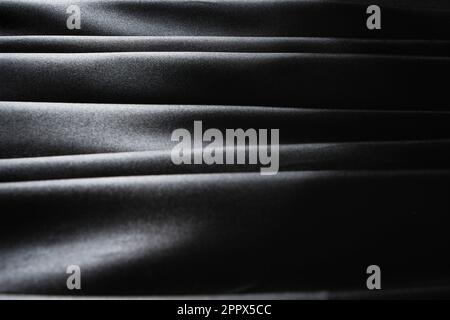 Horizontal lines of silk fabric, black abstract background of satin fabric Stock Photo